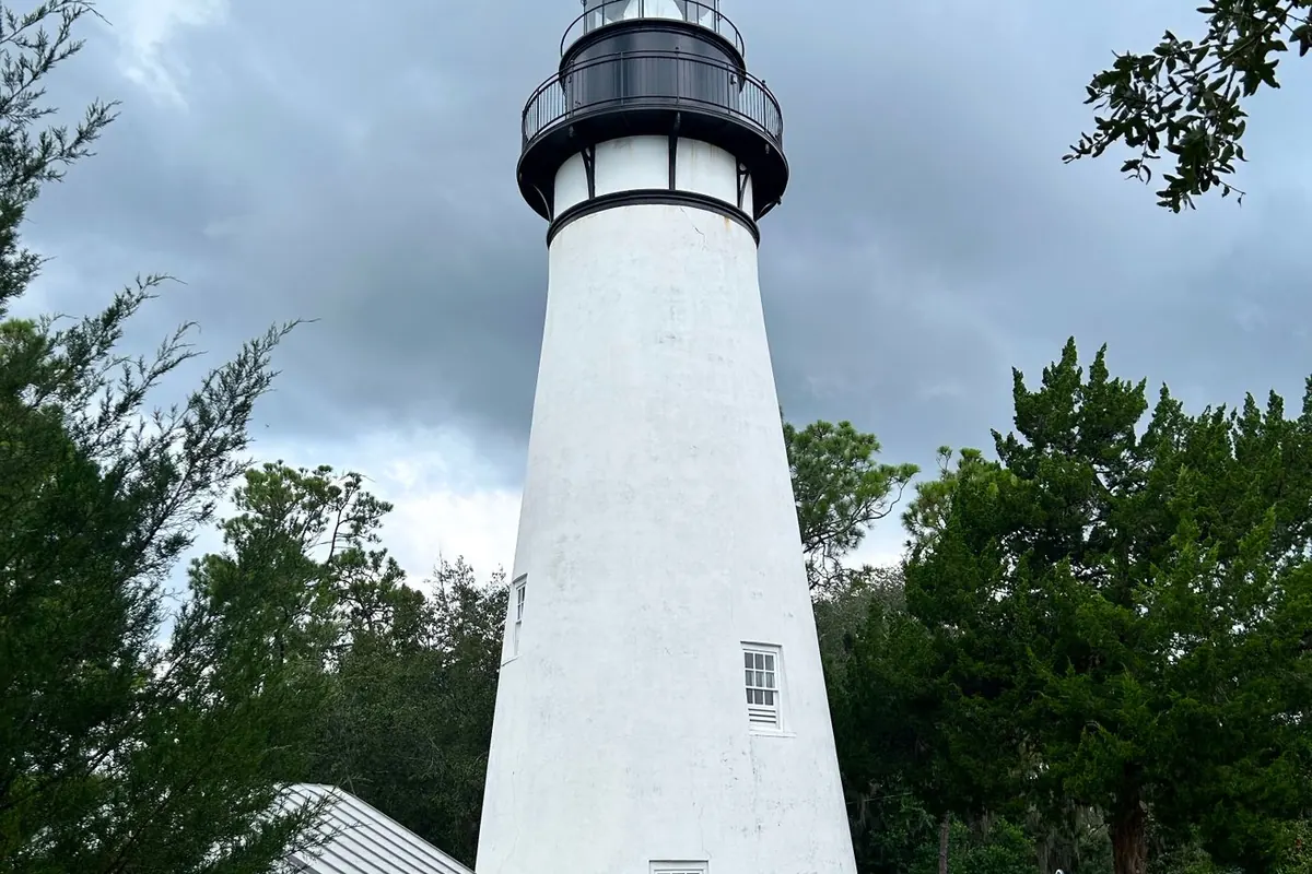The white Amelia Island Lighthouse among trees in Fernandina Beach